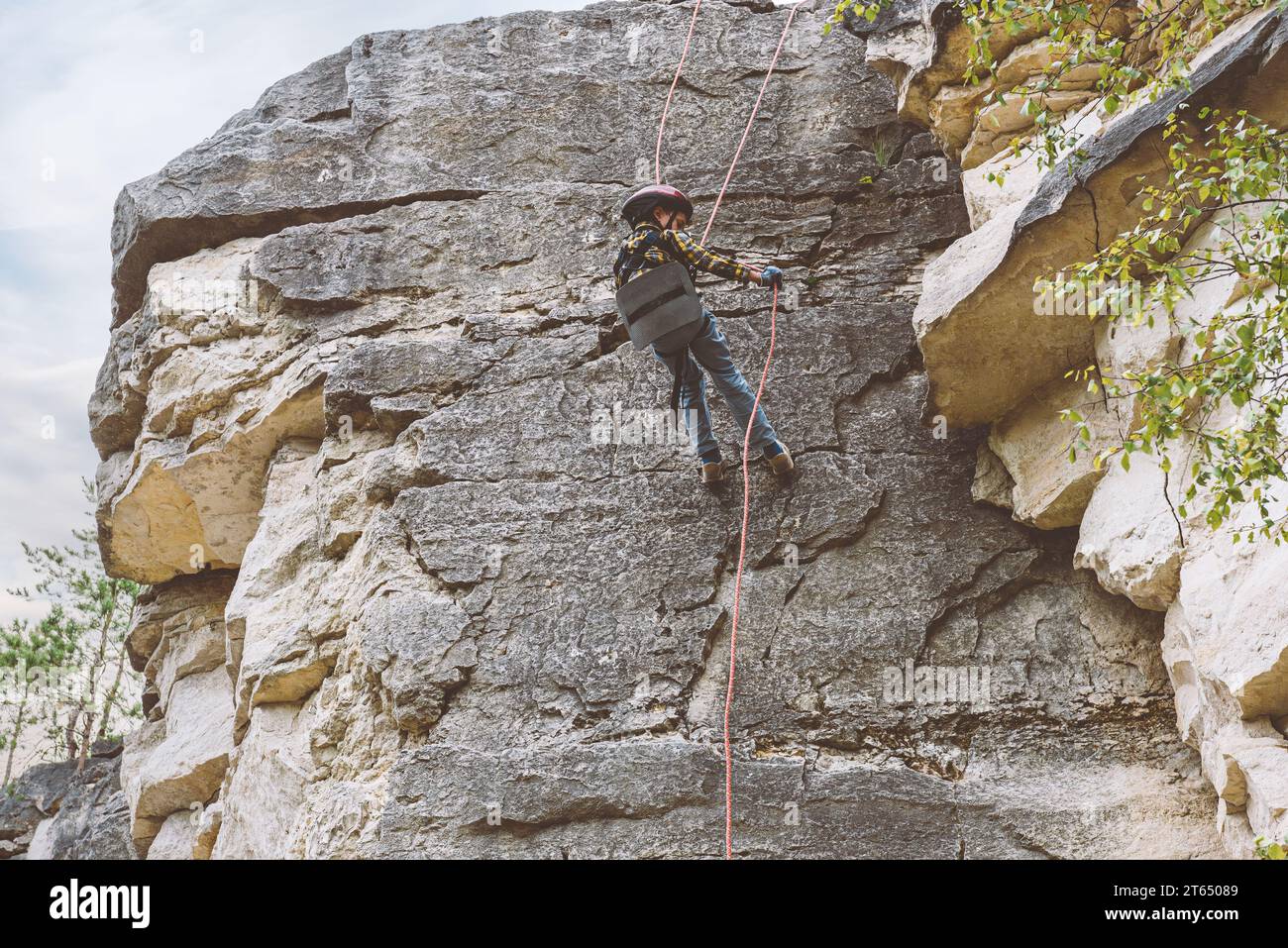 Small kid at rock climbing training learning basics of abseiling Stock Photo
