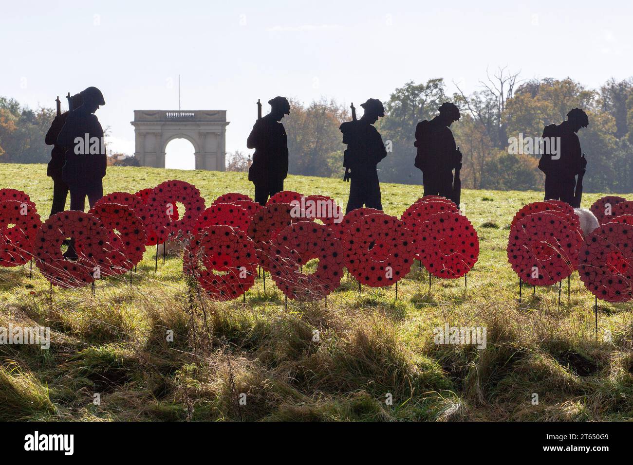 metal soldier silhouettes and poppies in the STANDING WITH GIANTS Remembrance Day art installation at Stowe Gardens, Buckinghamshire, England 11/2023 Stock Photo