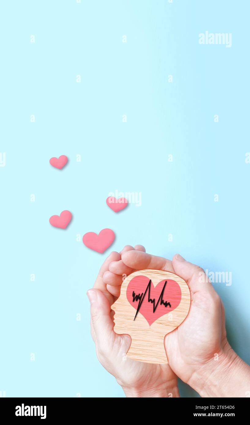 Hands holding wooden brain and heart, brain stroke, world heart day, world mental health day, Alzheimer and wellness concept Stock Photo