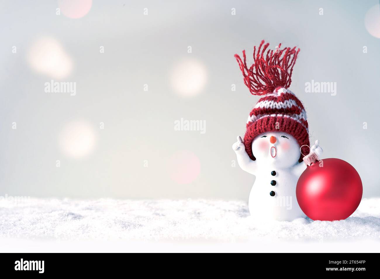 One little snowmen in caps on snow in the winter. Festive background with a funny snowman. Christmas card, copy space. Stock Photo