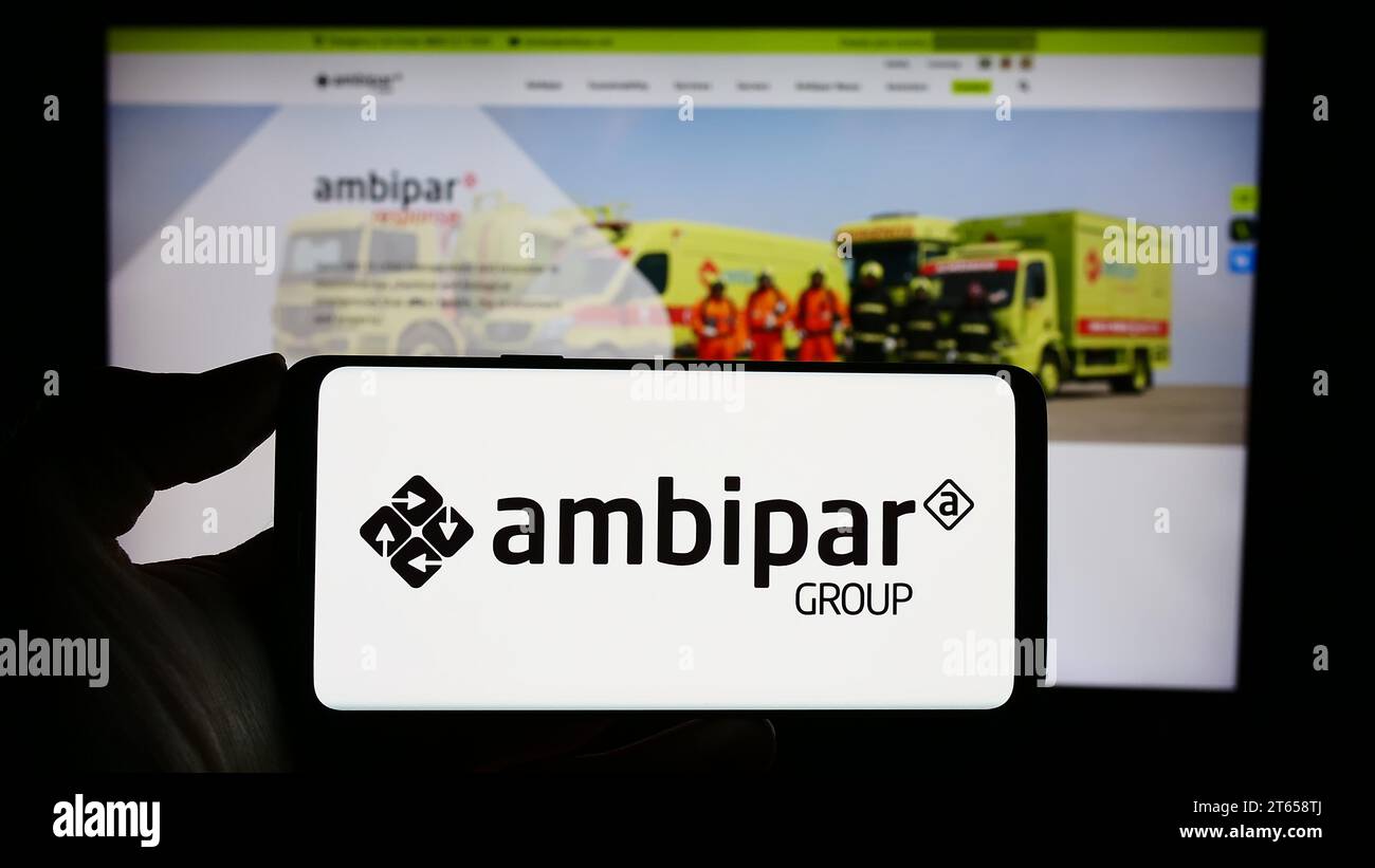 Person holding cellphone with logo of Brazilian environmental services company Ambipar Group in front of webpage. Focus on phone display. Stock Photo