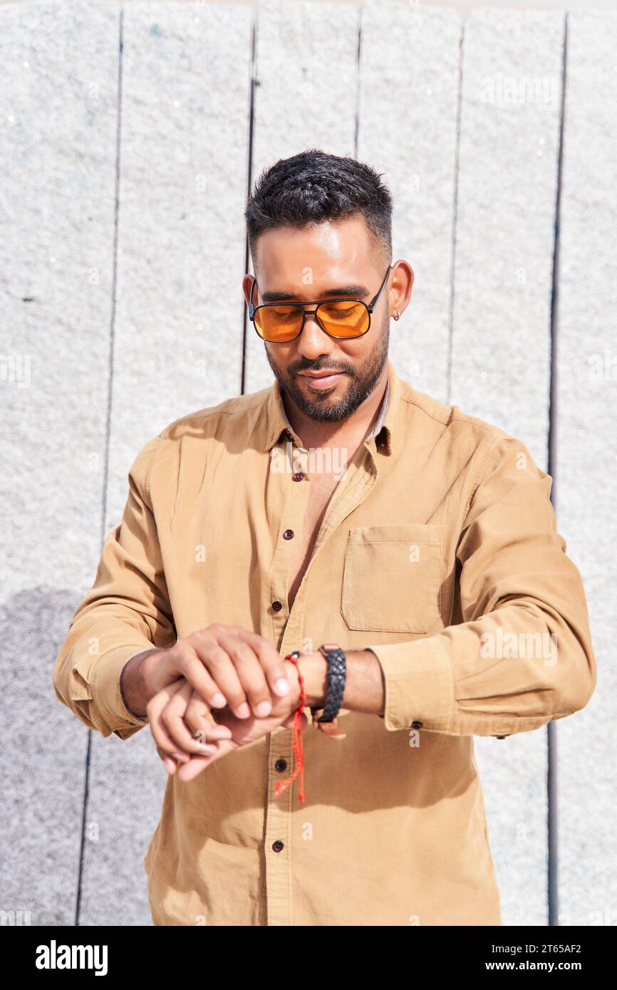 portrait of a latin man with sunglasses looking at the clock Stock Photo