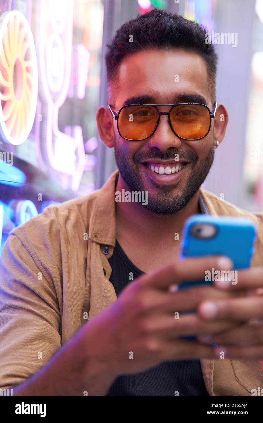 portrait of a latin man using his smart phone. portrait of a latin man using his smart phone. vertical photography social networking concept Stock Photo