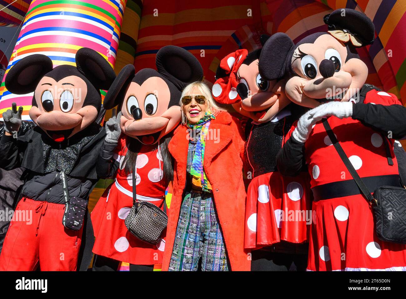 New York, USA. , . Argentinian conceptual pop artist Marta Minujín, 80, poses next to her 'Sculpture of Dreams' installation in Times Square along with characters representing Mickey and Minnie Mouse. The vibrant, large-scale, 16-piece inflatable in the artist's signature stripes is Minujín's first public sculpture in New York City in her sixty-year career, and is presented to coincide with the Jewish Museum's major survey exhibition of her work, Marta Minujín: Arte! Arte! Arte!, opening on November 17. Credit: Enrique Shore/Alamy Live News Stock Photo