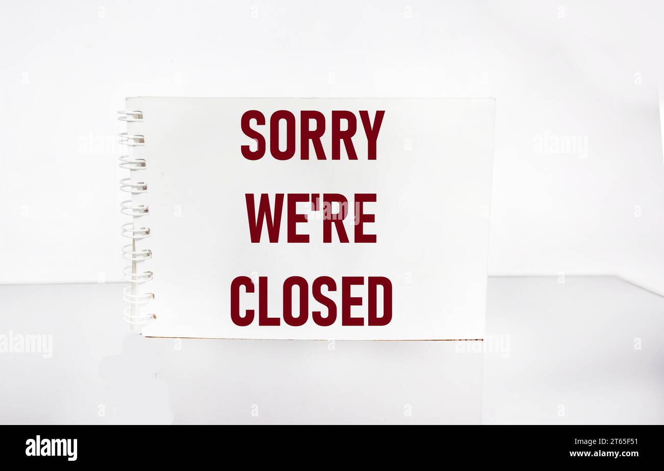 Closed business or store concept. Red letters on a notepad. Sorry we are closed on white background Stock Photo