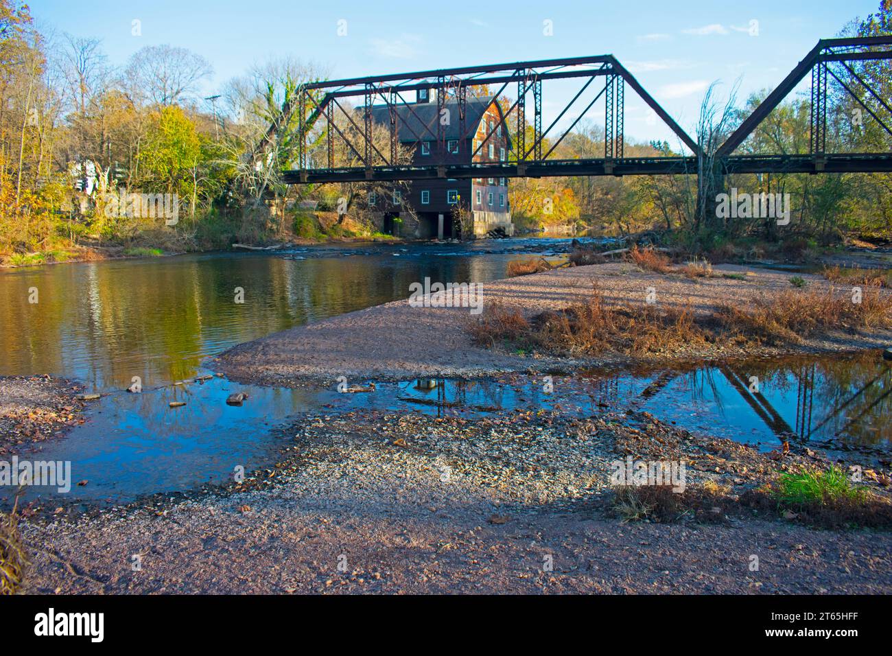 Historic mill house behind an abandoned railroad trestle spanning the