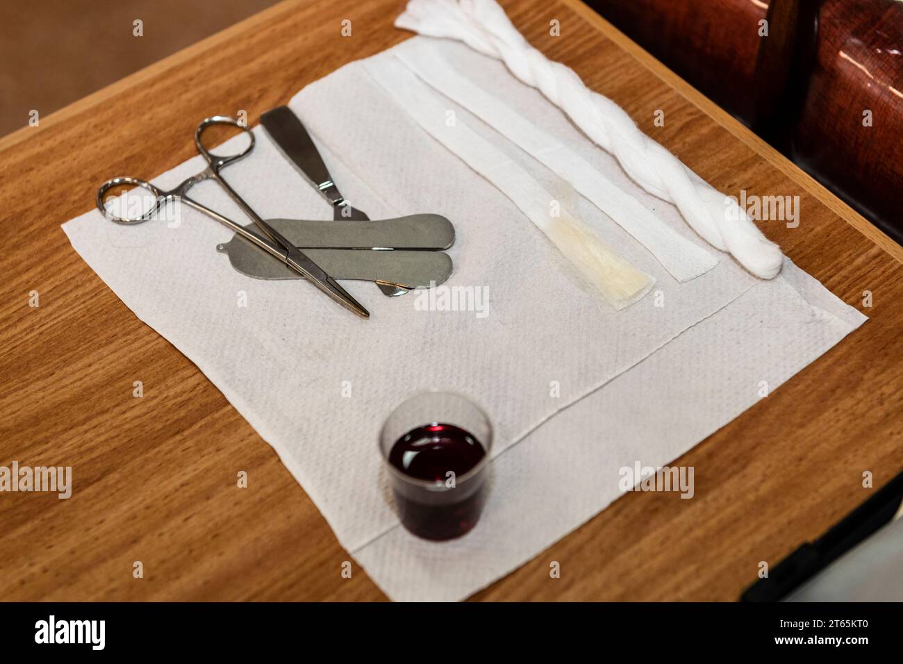 A mohel or ritual circumcisor prepares the instruments and ritual items, including wine, alcohol swabs and a cutting tool for a brit mila. Stock Photo