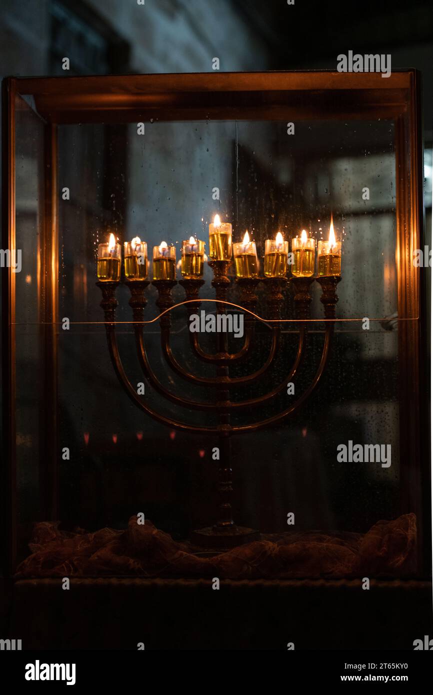 Burning Hanukkah candles cast a golden glow of firelight in the Old City of Jerusalem on the eighth night of the Festival of Lights in Israel. Stock Photo