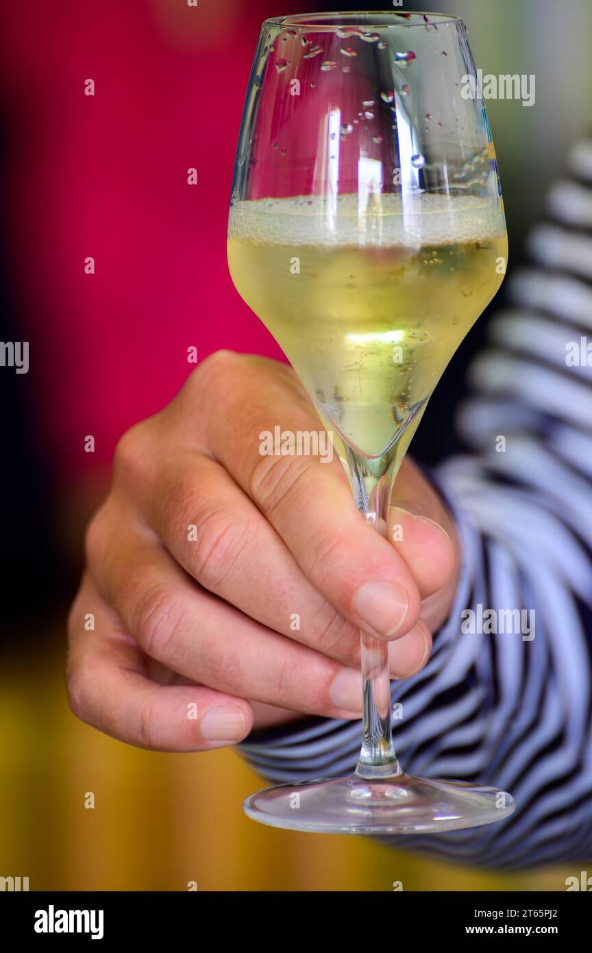 Tasting of sparkling white wine with bubbles champagne on summer
