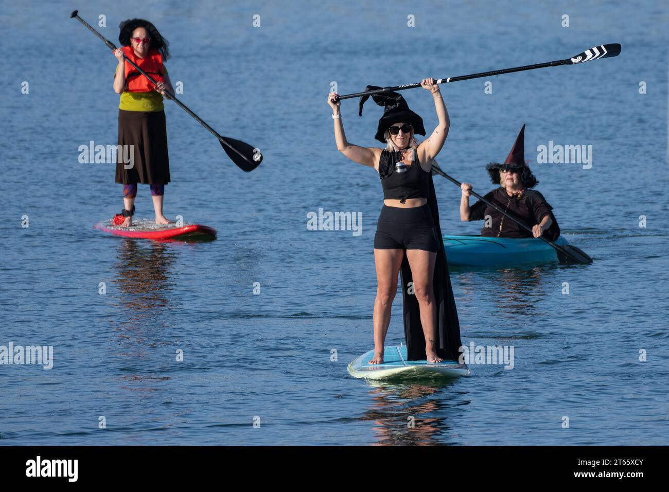 Stand up paddleboard Witch raises paddle in air in showing the