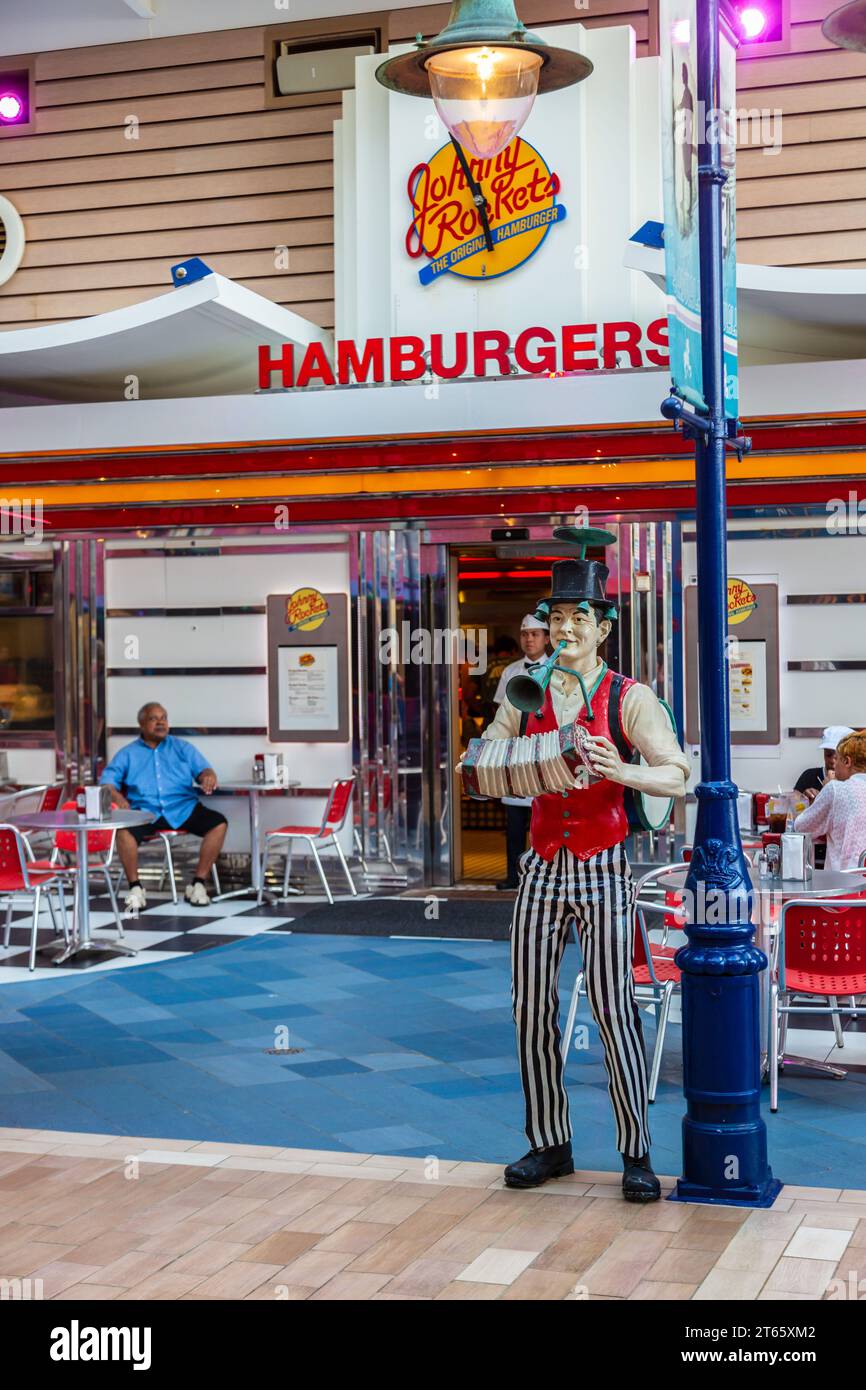 Statue of a man playing a squeeze box at a lamp post outside Johnny