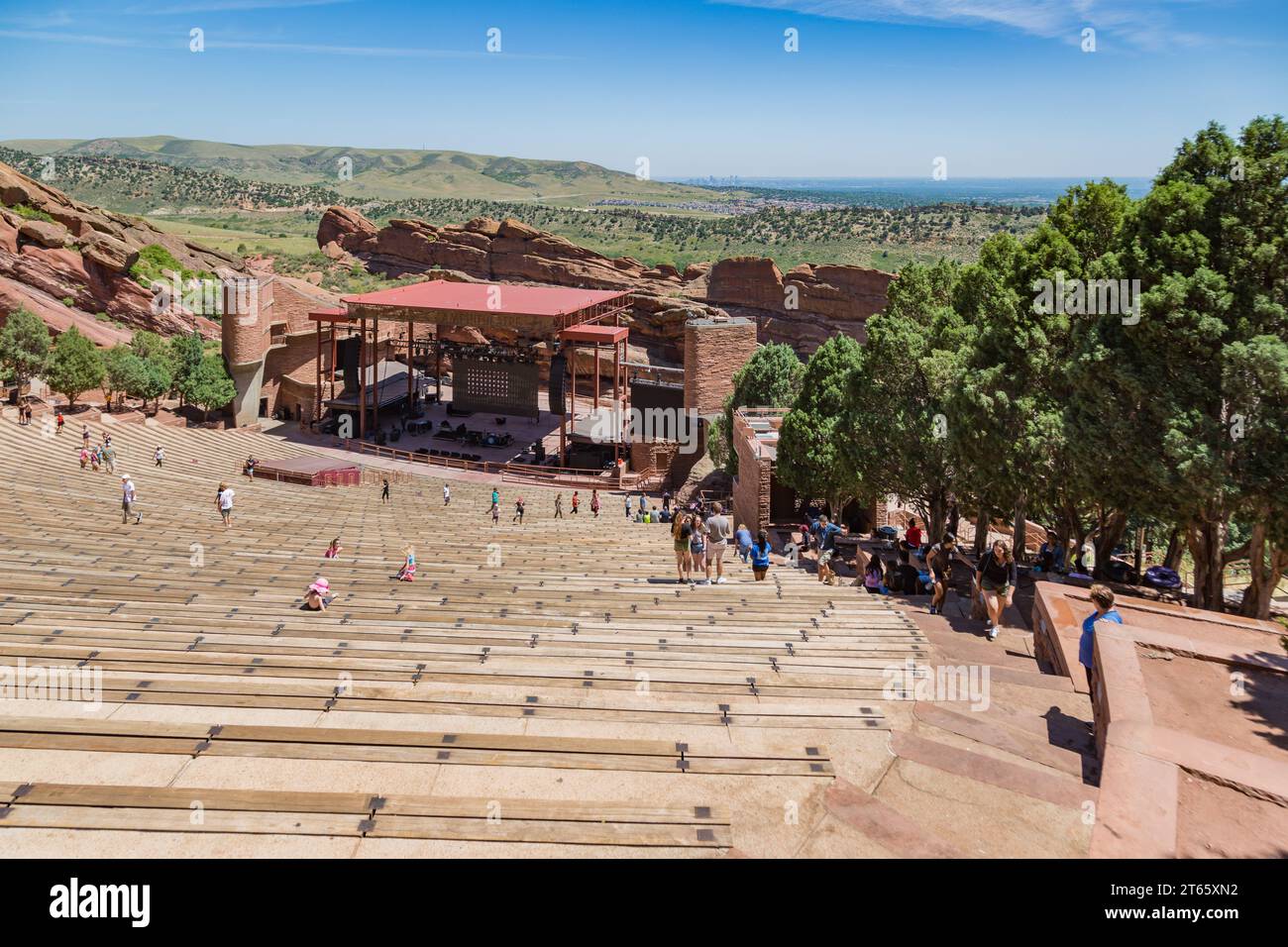 Visitors sit looking down onto stage from near the top of expansive Red Rocks Ampitheater seating area Stock Photo