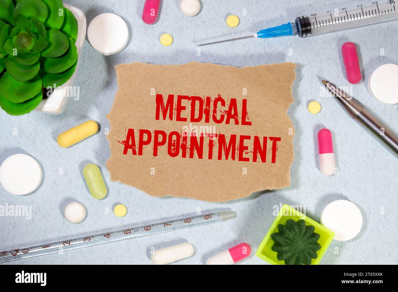Medical appointment. text on white paper, blue background, near pills and stethoscope in blue Stock Photo