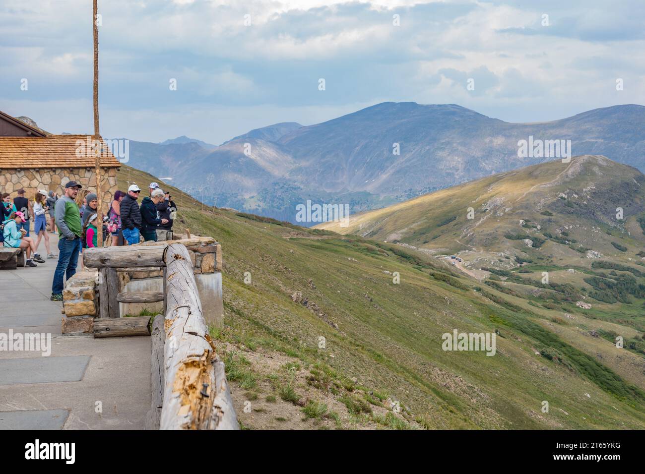 Tourists at a visitor's center overlook a valley between the mountains of Rocky Mountain National Park in Colorado Stock Photo