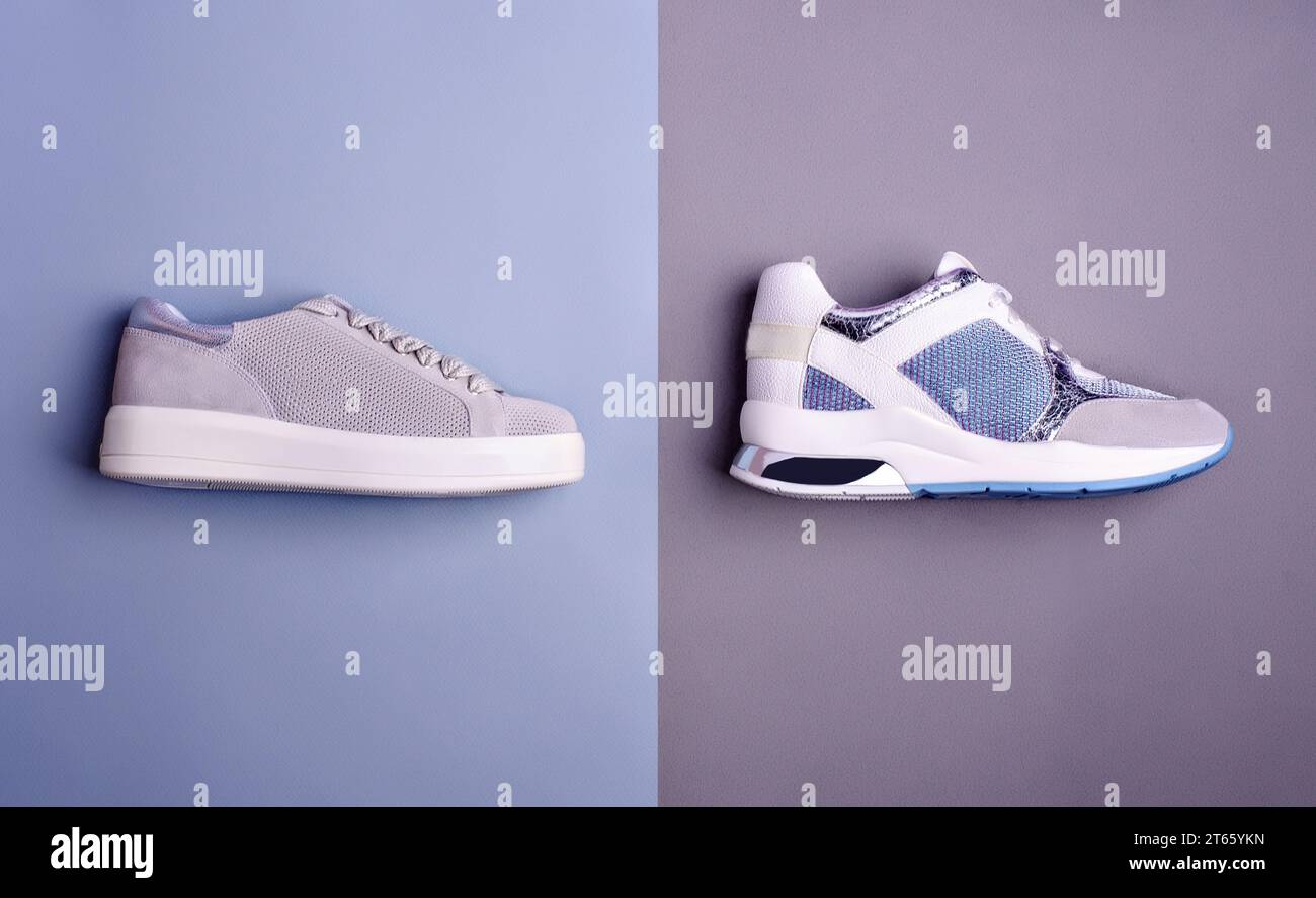 Side view of two trendy different sneakers in gray, white, and blue colors, isolated on a two-color blue-gray background. Top view, flat lay. Creative Stock Photo