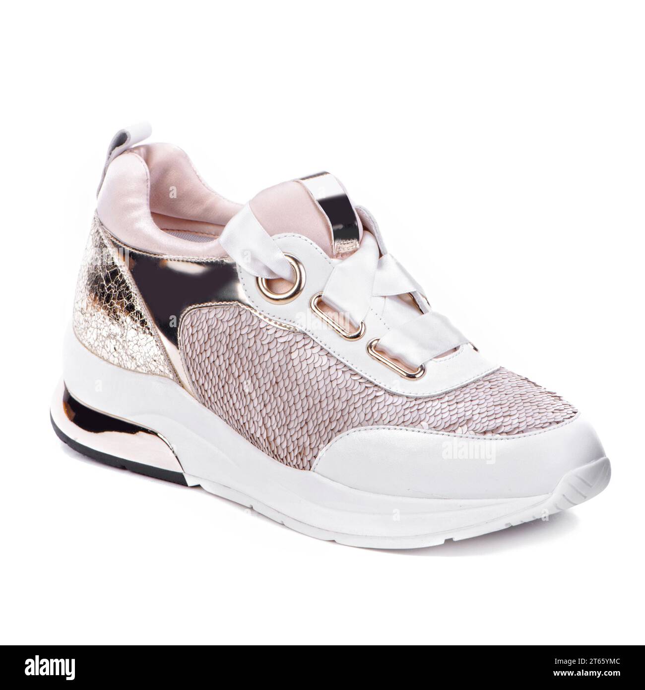 Fashionable women's sneaker with sequins immitating fish scales, white sole, metallic inserts, and white satin shoelaces isolated on a white backgroun Stock Photo