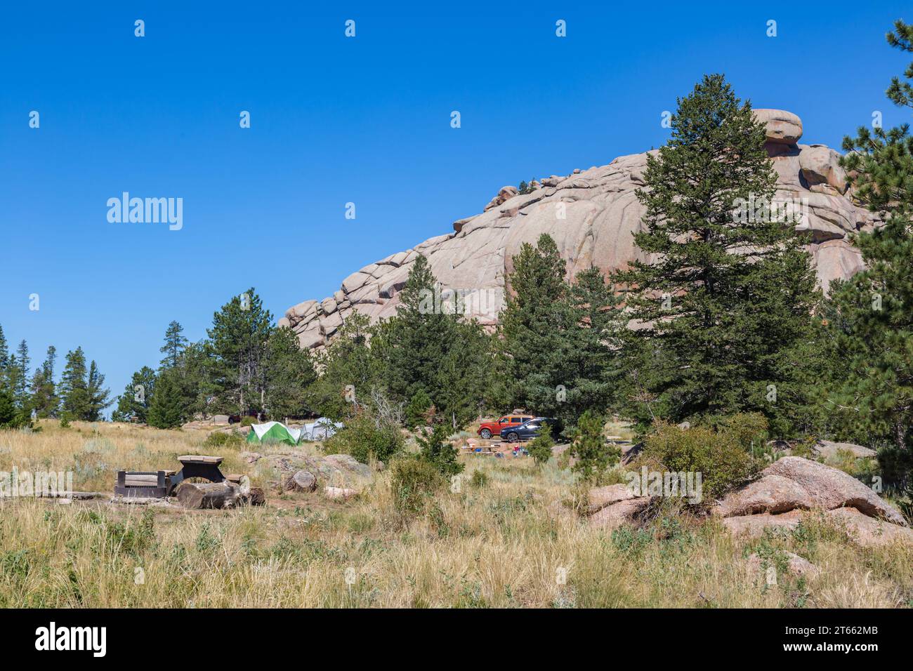 Granite rock outcropping behind camp sites with a picnic table, fire pit, and grill in the Vedauwoo Recreation Area of Medicine Bow National Forest Stock Photo