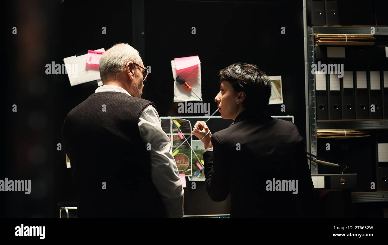 Experts team analyzing clues board in incident room, reviewing forensic