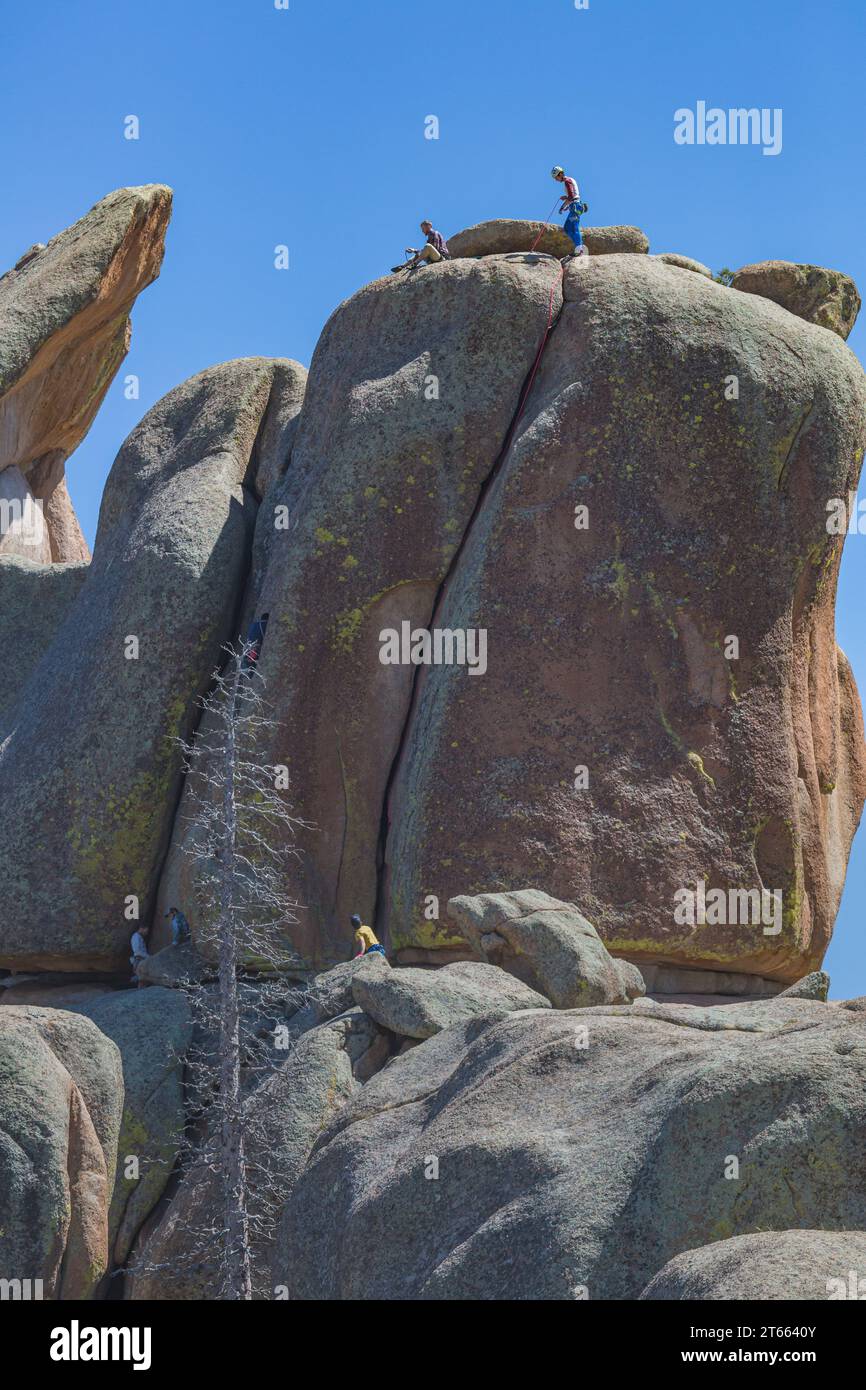 Men rock climbing on a large granite boulder in the Vedauwoo Recreation