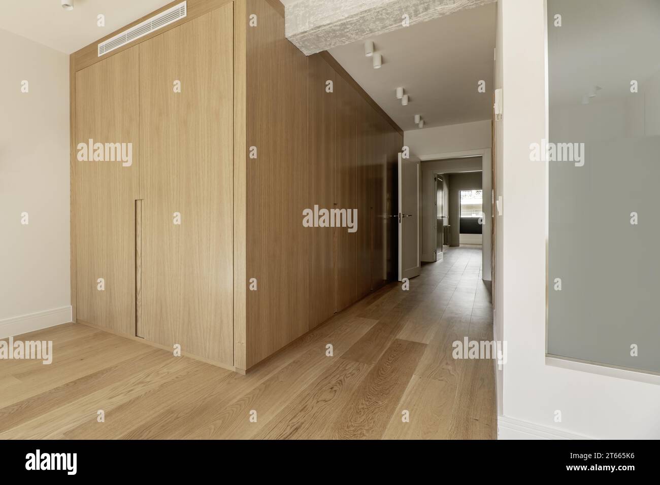 Hallway to a bedroom with built-in wardrobes with custom-made light oak ...