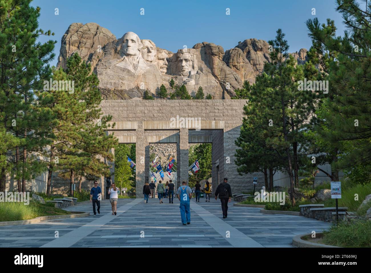 Carved granite busts of George Washington, Thomas Jefferson, Theodore Teddy Roosevelt and Abraham Lincoln above the Avenue of Flags at Mount Rushmore Stock Photo