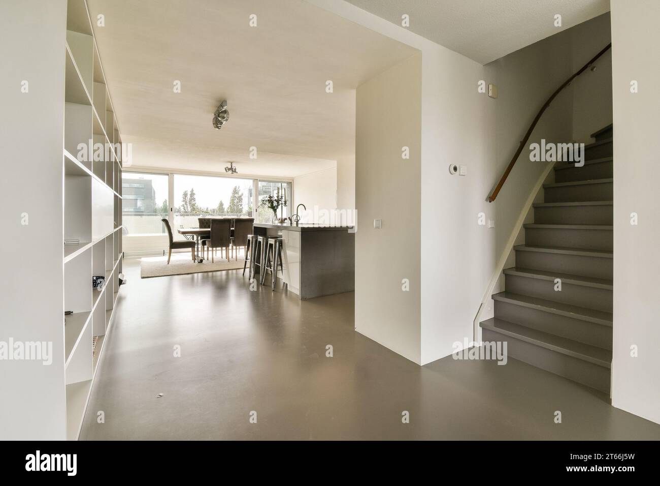 a living room with stairs leading up to the kitchen and dining area on