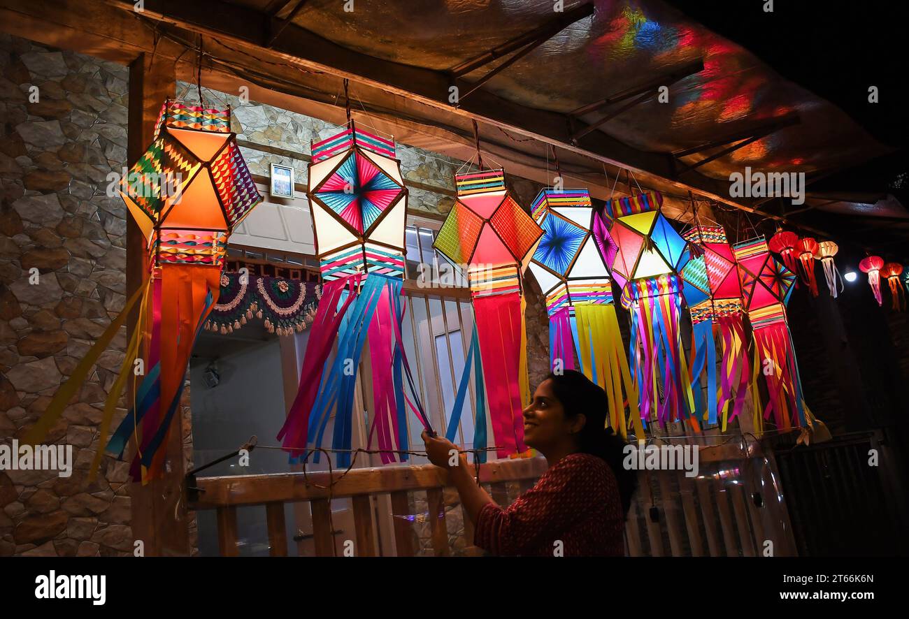 Mumbai, India. 08th Nov, 2023. A woman poses for a photo near the lanterns kept for sale ahead of the Hindu festival of lights, Diwali in Mumbai. Diwali festival is celebrated by Hindus where they shop for lanterns ahead of the festival, clean their home, prepare sweets and snacks, make rangoli (traditional Indian art form where various designs are made on the floor) and light their homes with earthen lamps marking victory of light over darkness. Credit: SOPA Images Limited/Alamy Live News Stock Photo