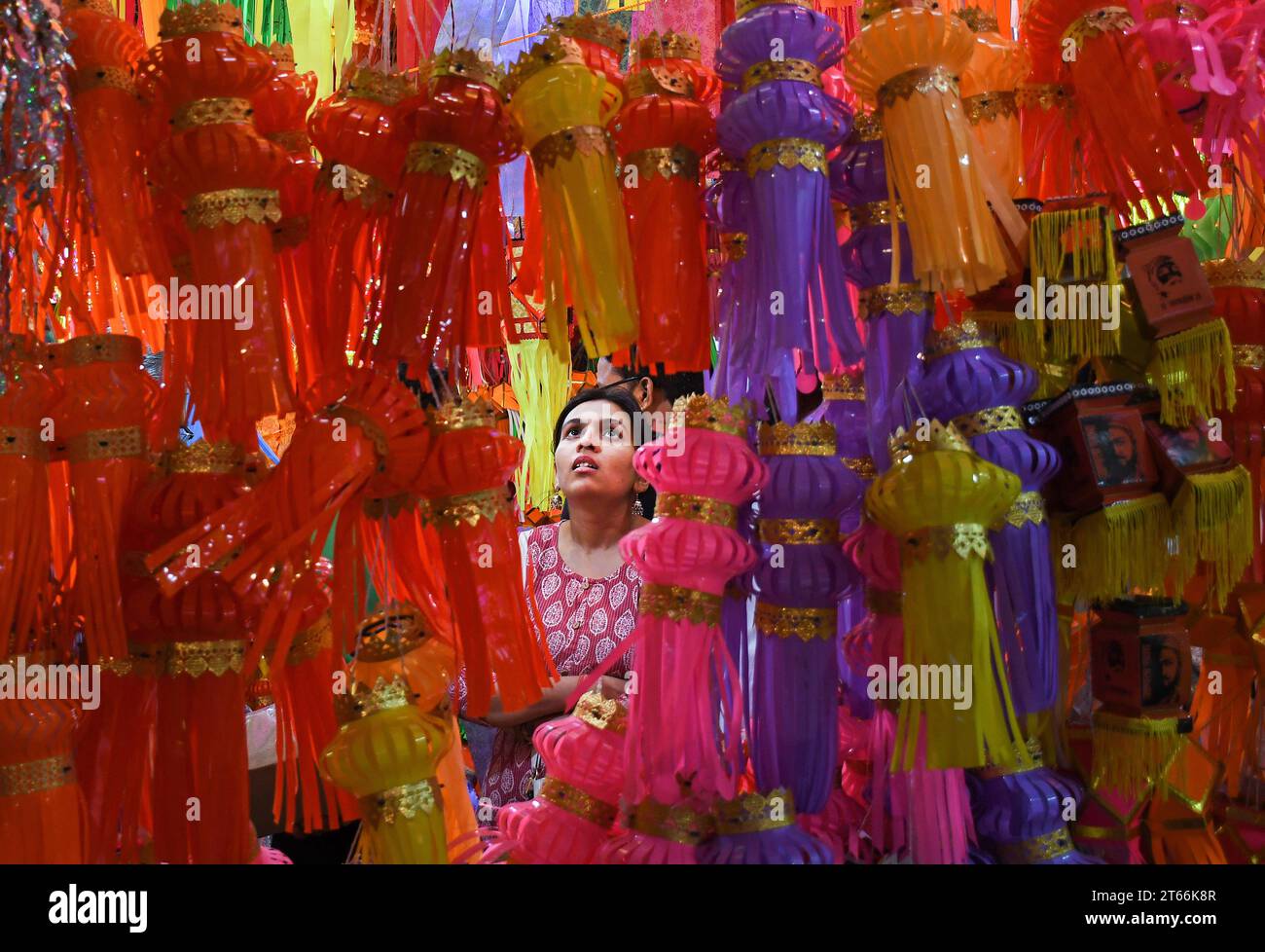 Mumbai, India. 08th Nov, 2023. A woman shops for lanterns ahead of the Hindu festival of lights, Diwali in Mumbai. Diwali festival is celebrated by Hindus where they shop for lanterns ahead of the festival, clean their home, prepare sweets and snacks, make rangoli (traditional Indian art form where various designs are made on the floor) and light their homes with earthen lamps marking victory of light over darkness. Credit: SOPA Images Limited/Alamy Live News Stock Photo