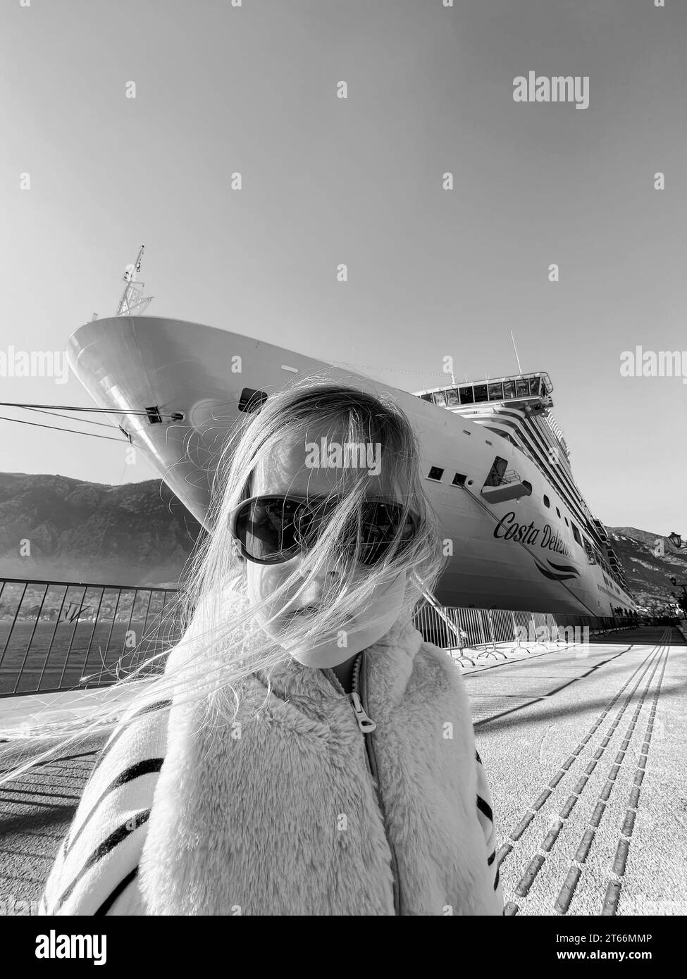 Little girl in sunglasses with flying hair on the background of a