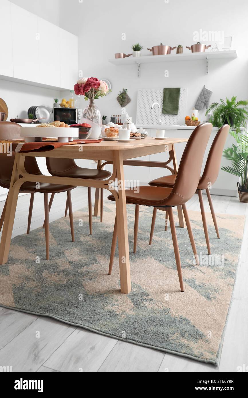 Served dining table on stylish carpet in modern kitchen Stock Photo - Alamy
