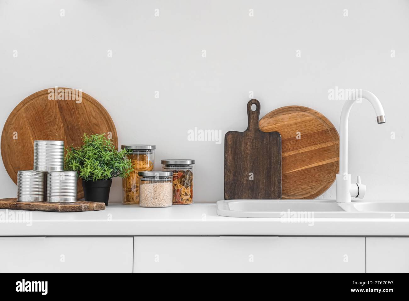 White counters with sink and utensils in interior of modern kitchen ...