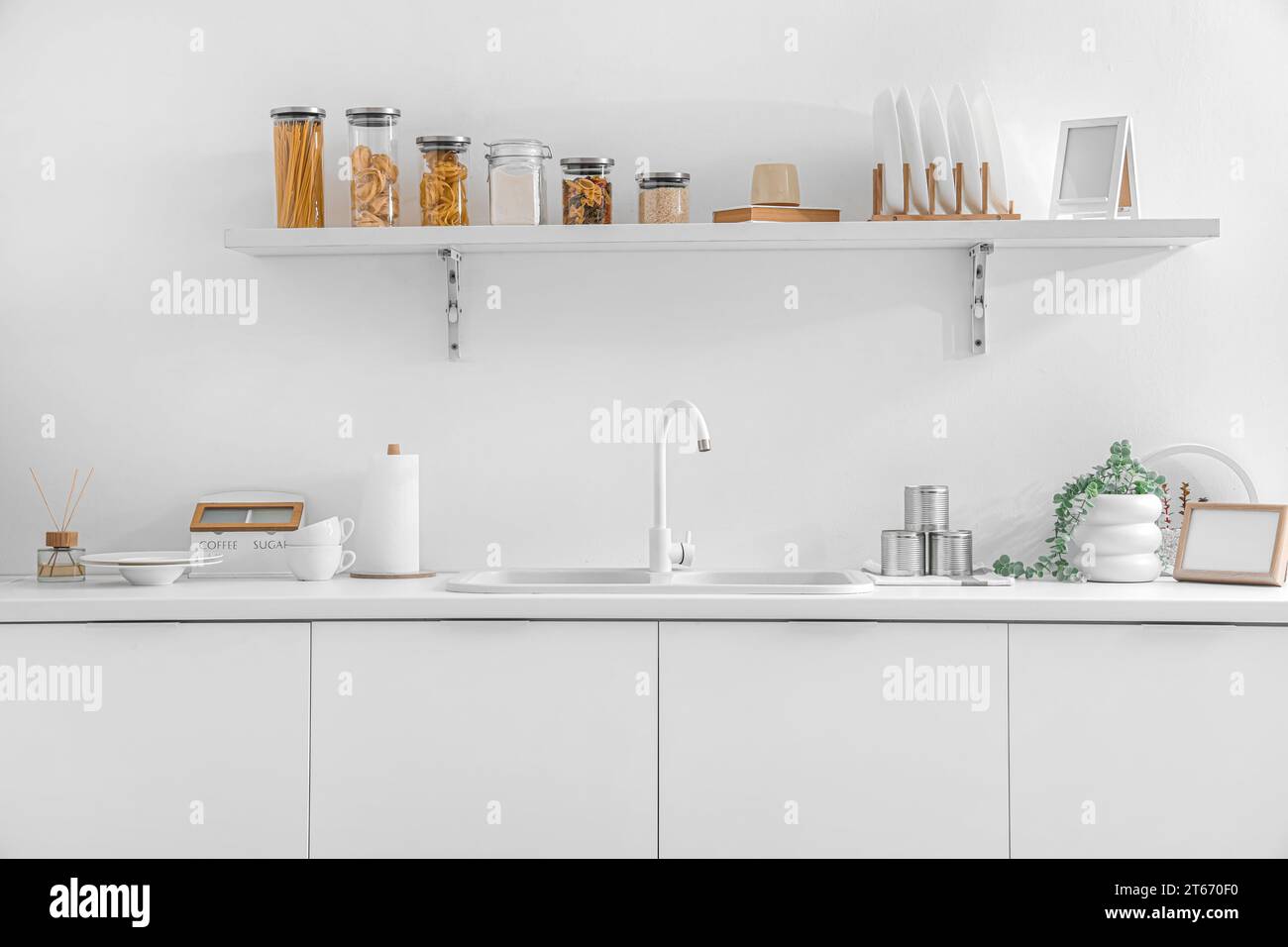 White counters with sink and utensils in interior of modern kitchen ...