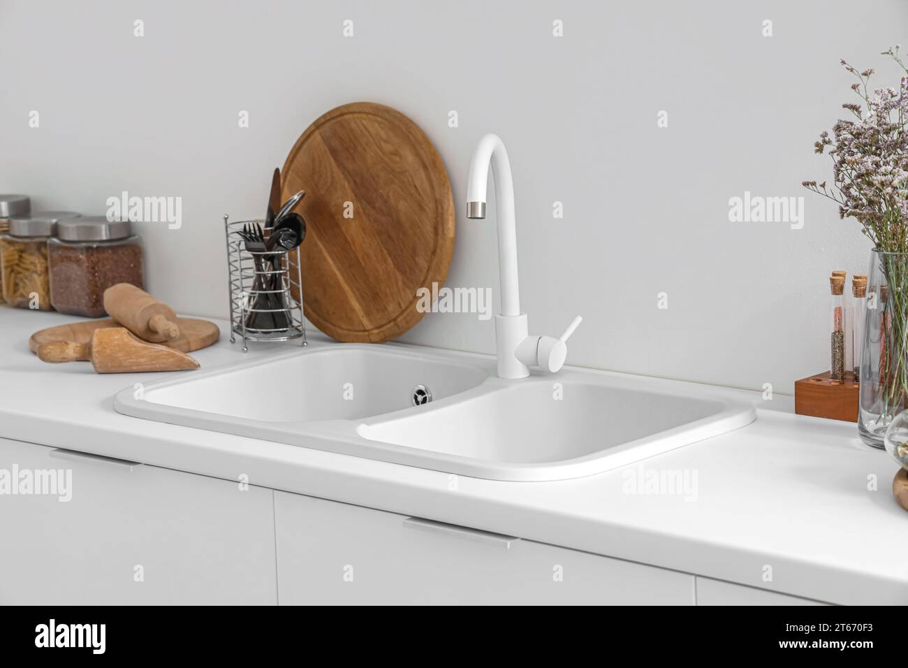 White counters with sink and utensils in interior of modern kitchen ...