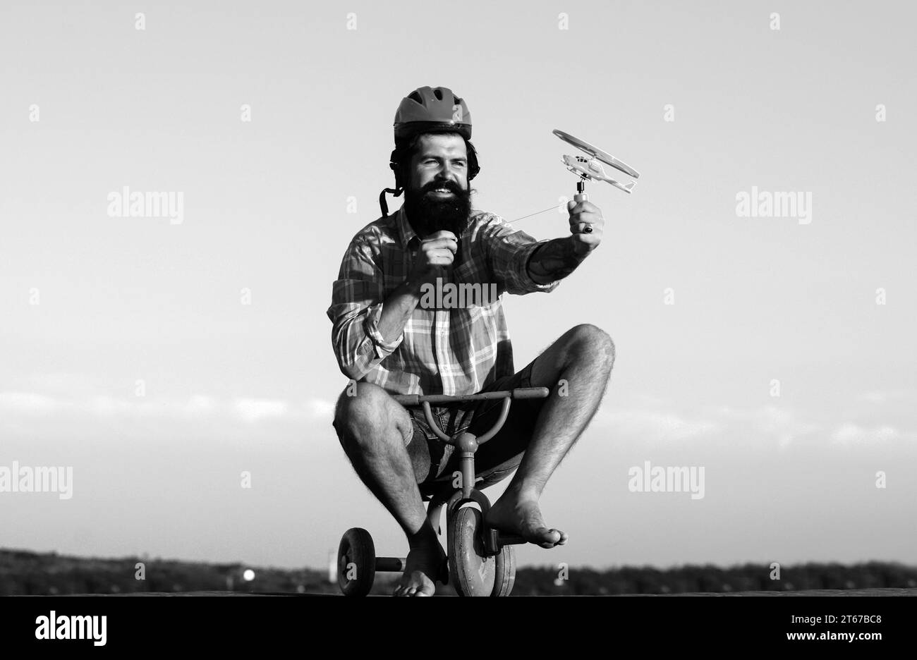 Childhood memory. Crazy Young man riding three wheeled bicycle Stock