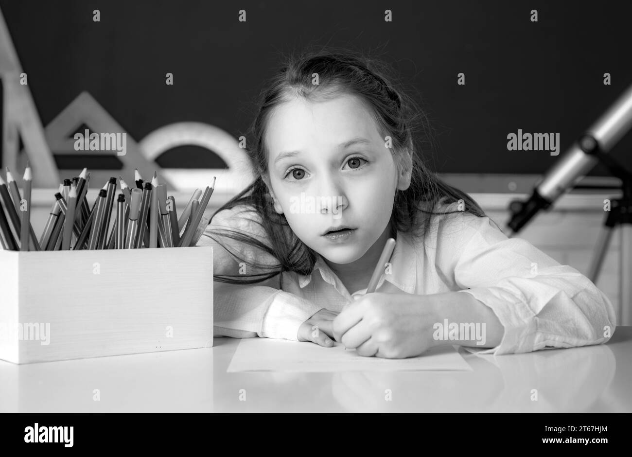 Cute little schoolgirl drawing an house and looking at camera Stock ...