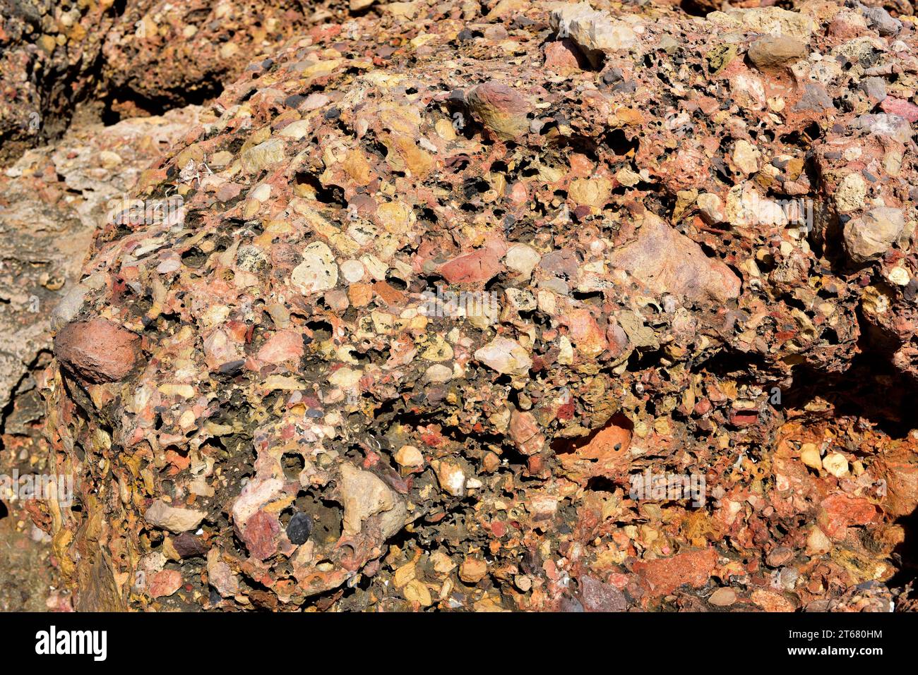 Conglomerate is a clastic sedimentary rock. This photo was taken in L'Ametlla de Mar coast, Tarragona province, Catalonia, Spain. Stock Photo