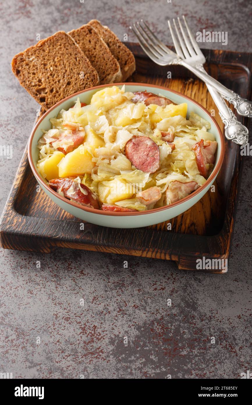 Jagerkohl German Hunter Cabbage Stew close-up in a bowl on the table. Vertical Stock Photo