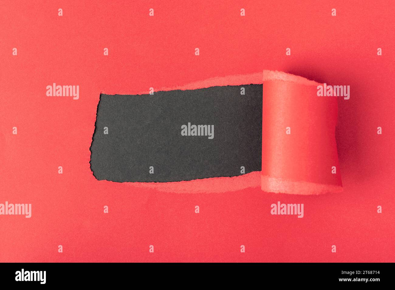 Hole in red paper on black background. Mockup. Stock Photo