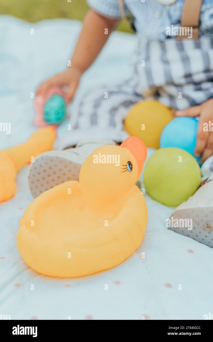 https://c8.alamy.com/comp/2T68GCC/a-cheerful-toddler-sits-in-a-brightly-lit-room-surrounded-by-toys-the-most-prominent-of-which-is-a-cheerful-orange-rubber-duck-2T68GCC.jpg