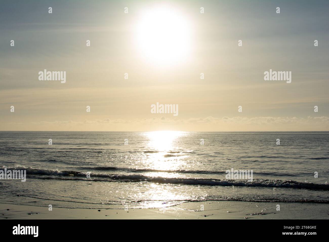 Sunrise on the sea around a sandy beach Stock Photo - Alamy