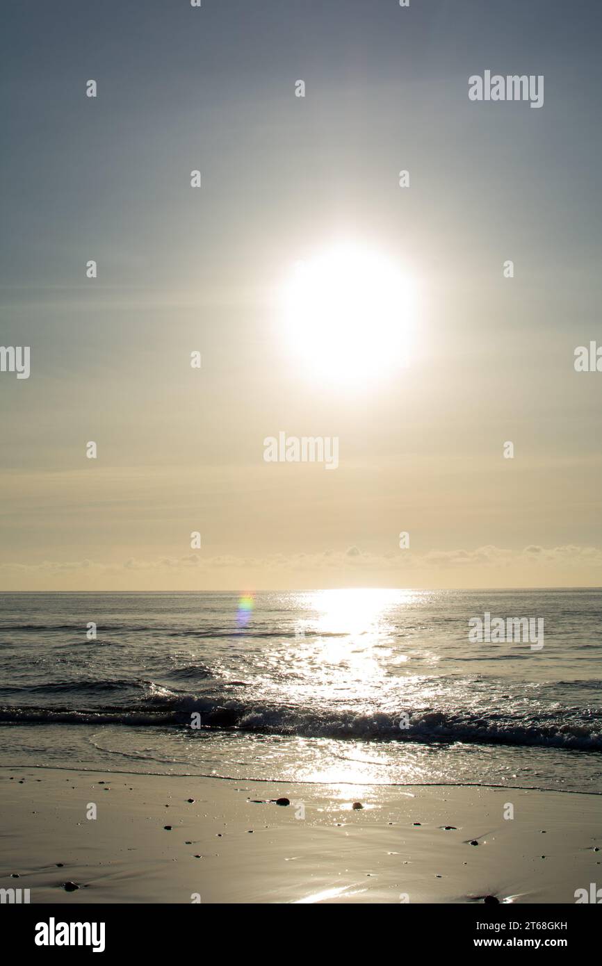 Sunrise on the sea around a sandy beach Stock Photo - Alamy