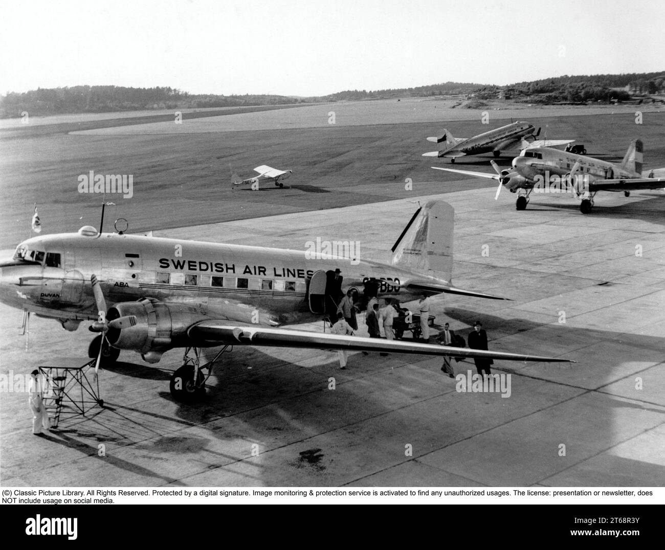 1950s airport. People are arriving by a Swedish airlines Douglas DC-3 plane to Bromma airport in Stockholm in the 1950s. Stock Photo