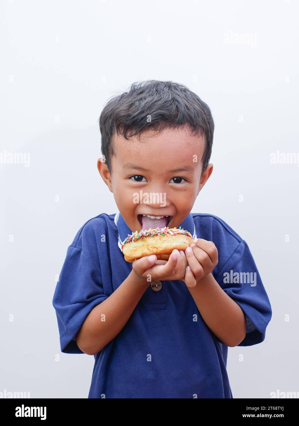 cute little asian boy eating donut isolated on white background Stock Photo