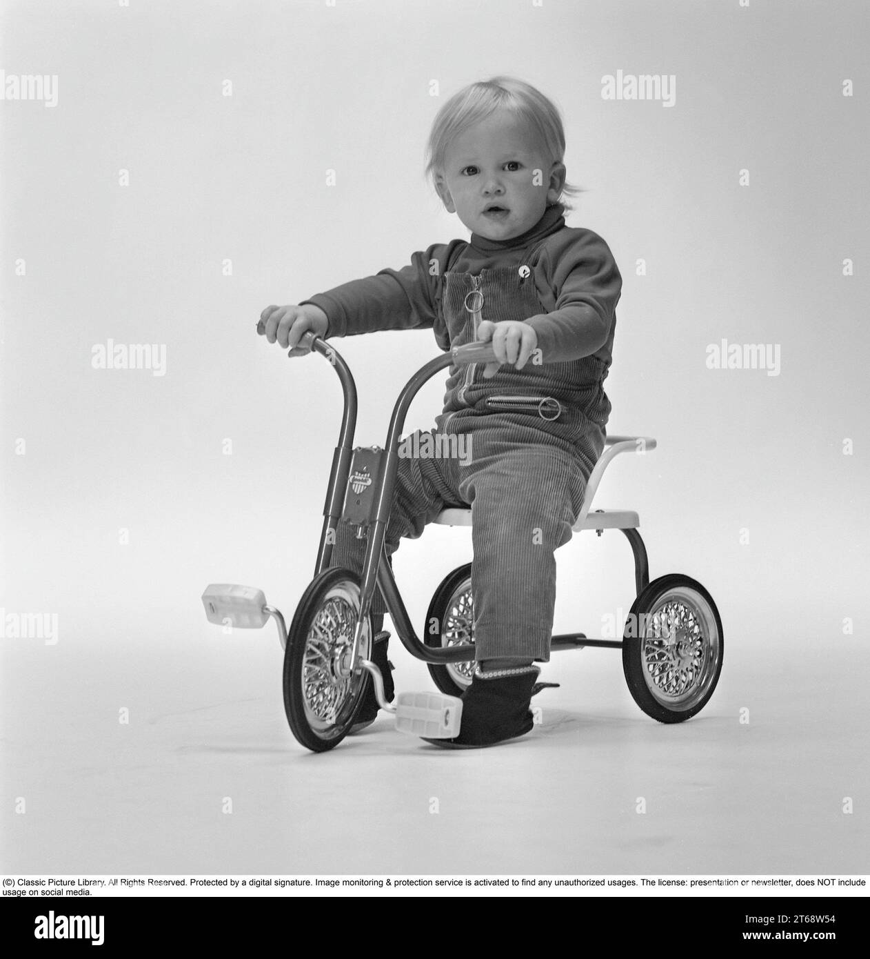 In the 1960s. A blonde boy on a tricycle. Sweden 1961 Stock Photo