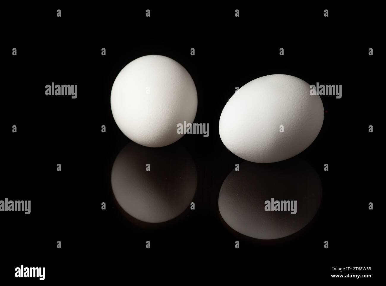 White chicken eggs on black background with reflection Stock Photo - Alamy