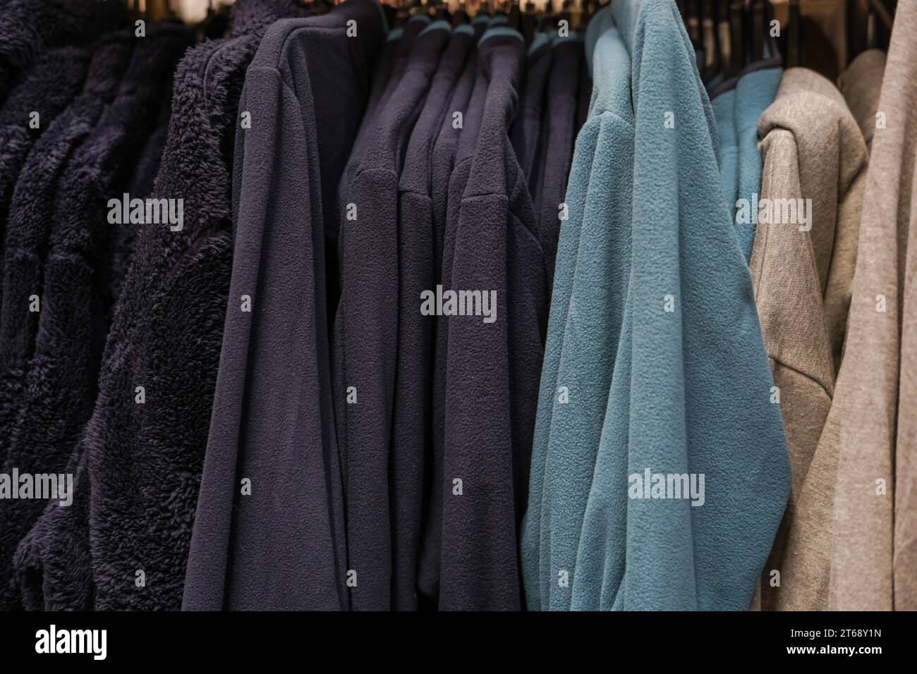 men's sportswear hanging on hangers in a store Stock Photo