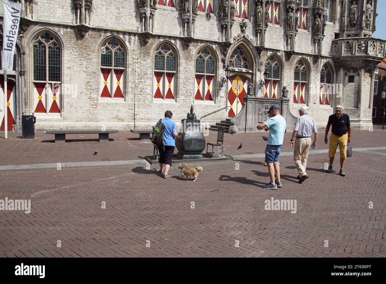 A model of Middelburg on a plinth with the Gothic town hall and two chairs and tourists on the Markt in front of the town hall. Netherlands, June Stock Photo