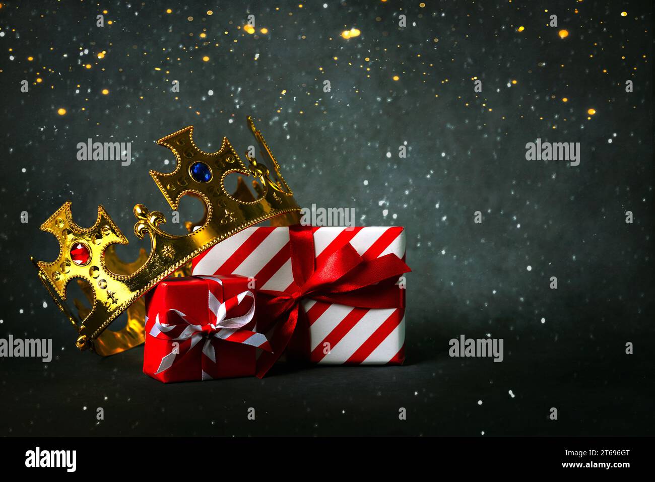 Crown of the three wise men with Christmas gift boxes and christmas lights over gray background. Concept for Dia de Reyes Magos day. Three Wise Men Stock Photo