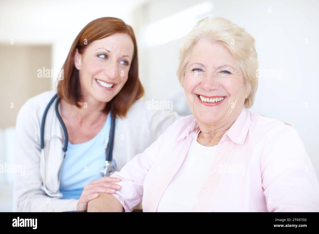 Relieved and ecstatic about her clean diagnosis. Happy elderly female patient receives some welcome company from her nurse. Stock Photo