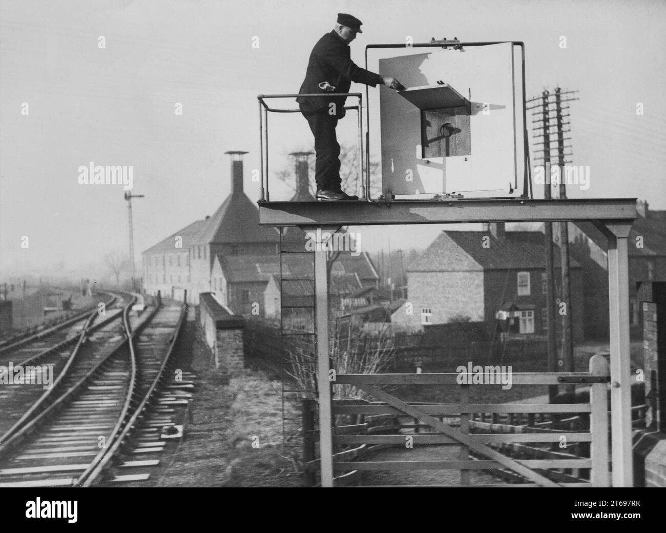 New signal system of the London and North Eastern Railway: an employee at an entry signal outside a station on the Knaresborough Line. A raised store reveals a green area and a green light at night. [automated translation] Stock Photo